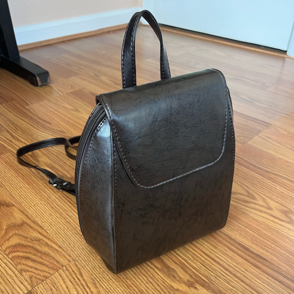 Brown hard shell faux leather backpack with adjustable straps